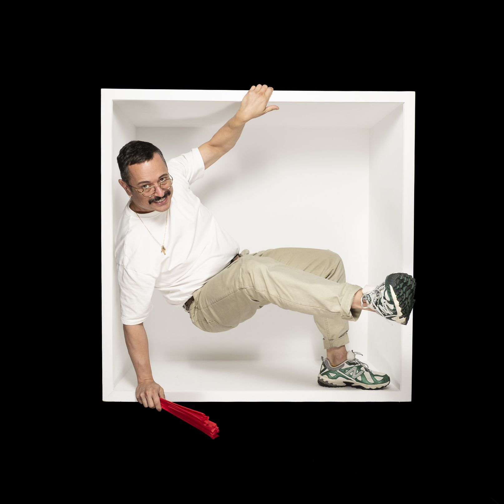 A sitter in a white shirt stretches across the box, holding a red fan as a leg extends beyond the side.
