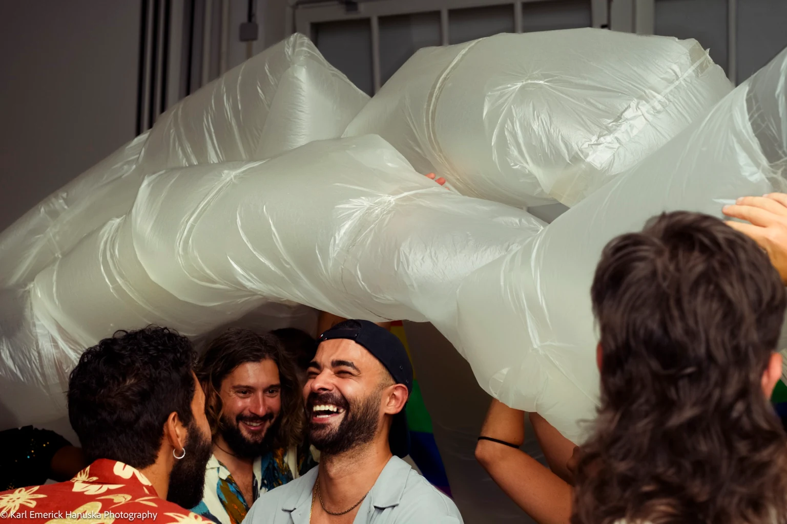 People laugh together beneath a large translucent inflatable sculpture.